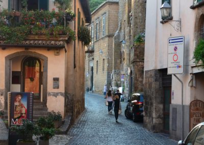 Tour guests walking down a cobblestone street in Orvieto.