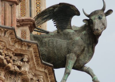 A sculpted stone ox head with horns on the exterior wall of the Florence Cathedral.