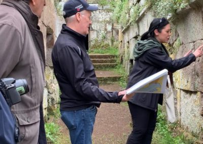 Local guide pointing to Etruscan tomb in Orvieto.