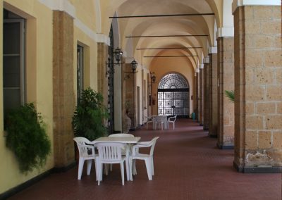 A scaled wide shot of an outdoor guest seating area in a boutique hotel courtyard.