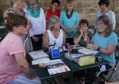 Art workshop guests watching a painting demonstration.